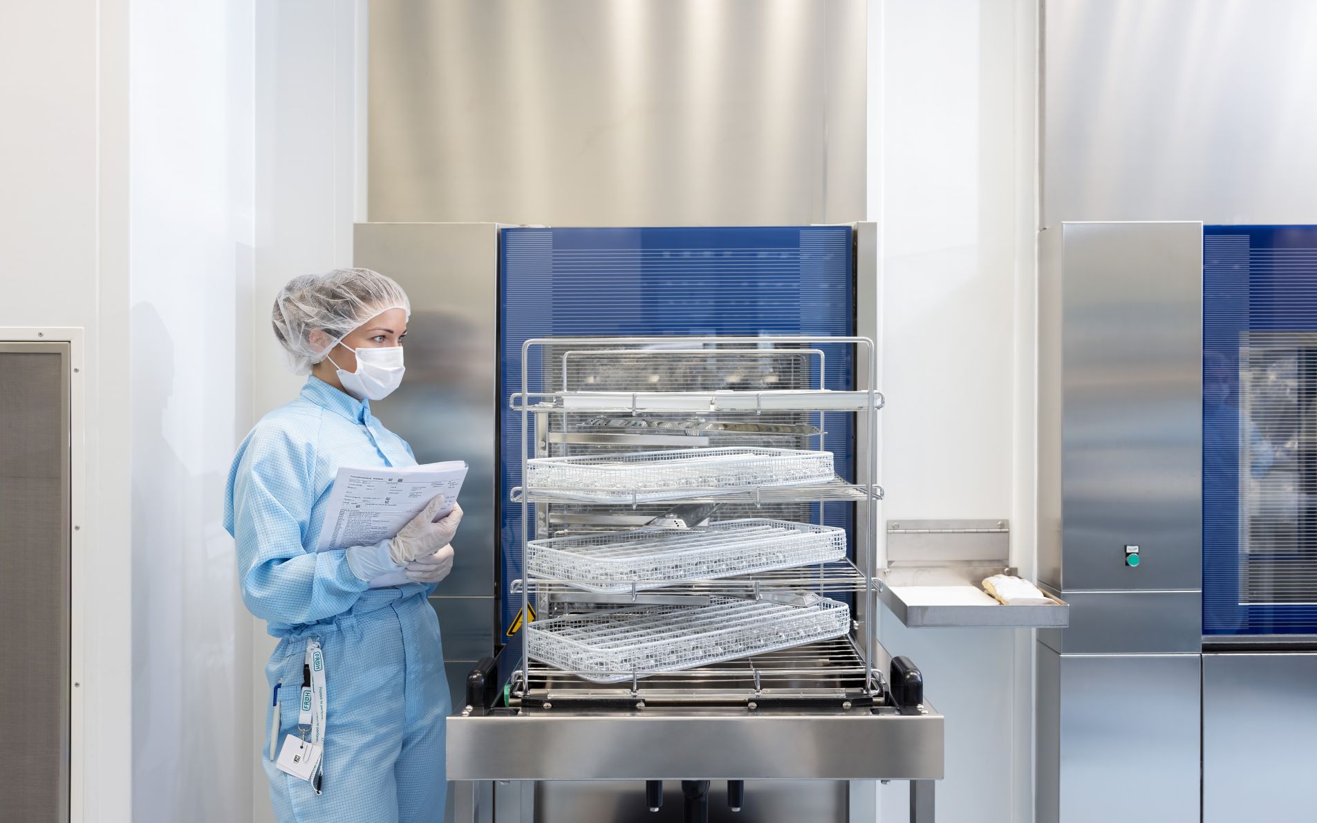 Woman checks rinsing basket in clean room